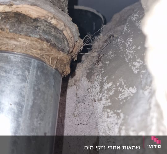 צינור מתכת עם חיבורים בתוך קיר שבור